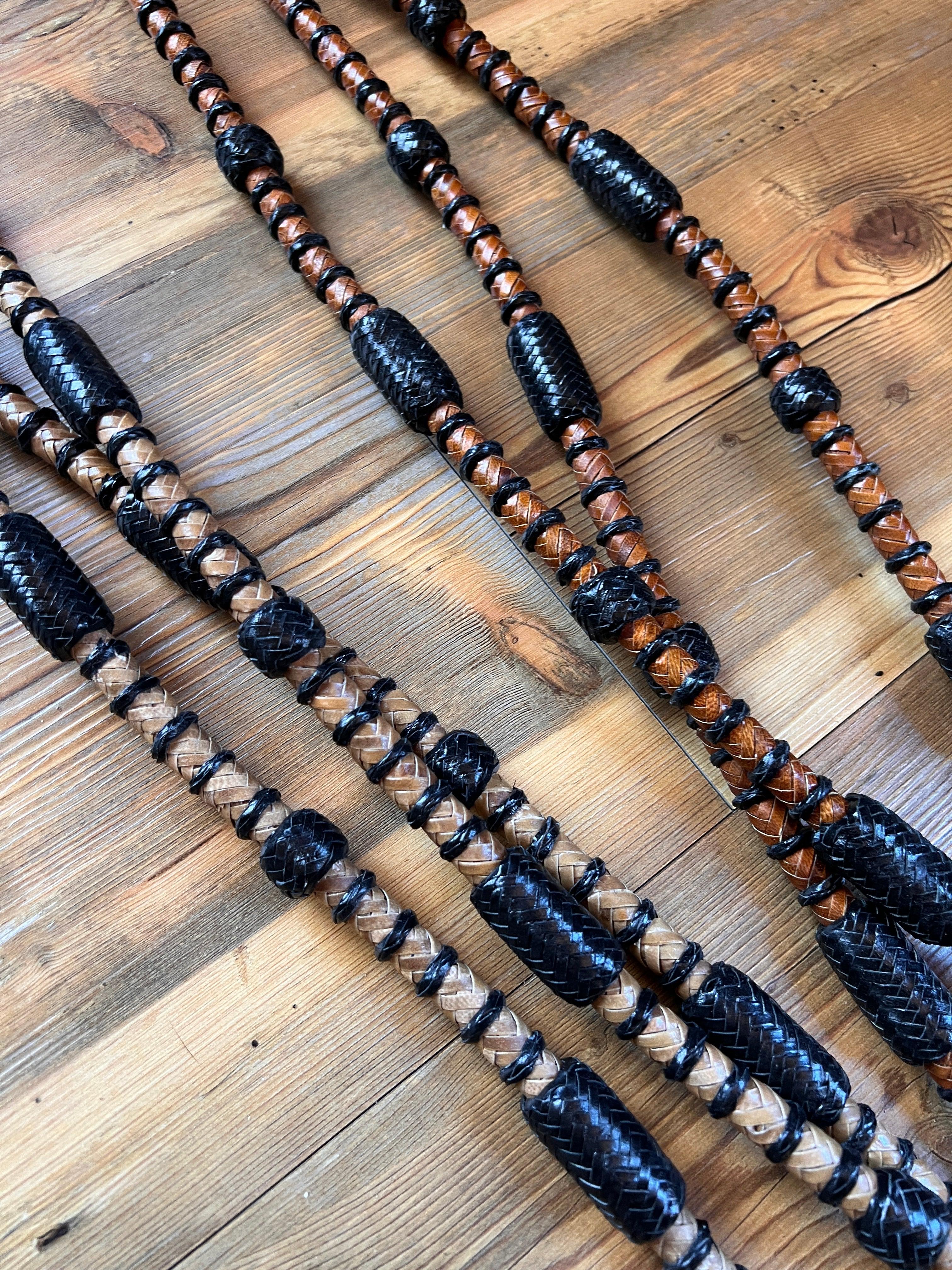 Black and tan braided rawhide Romal reins with woven texture