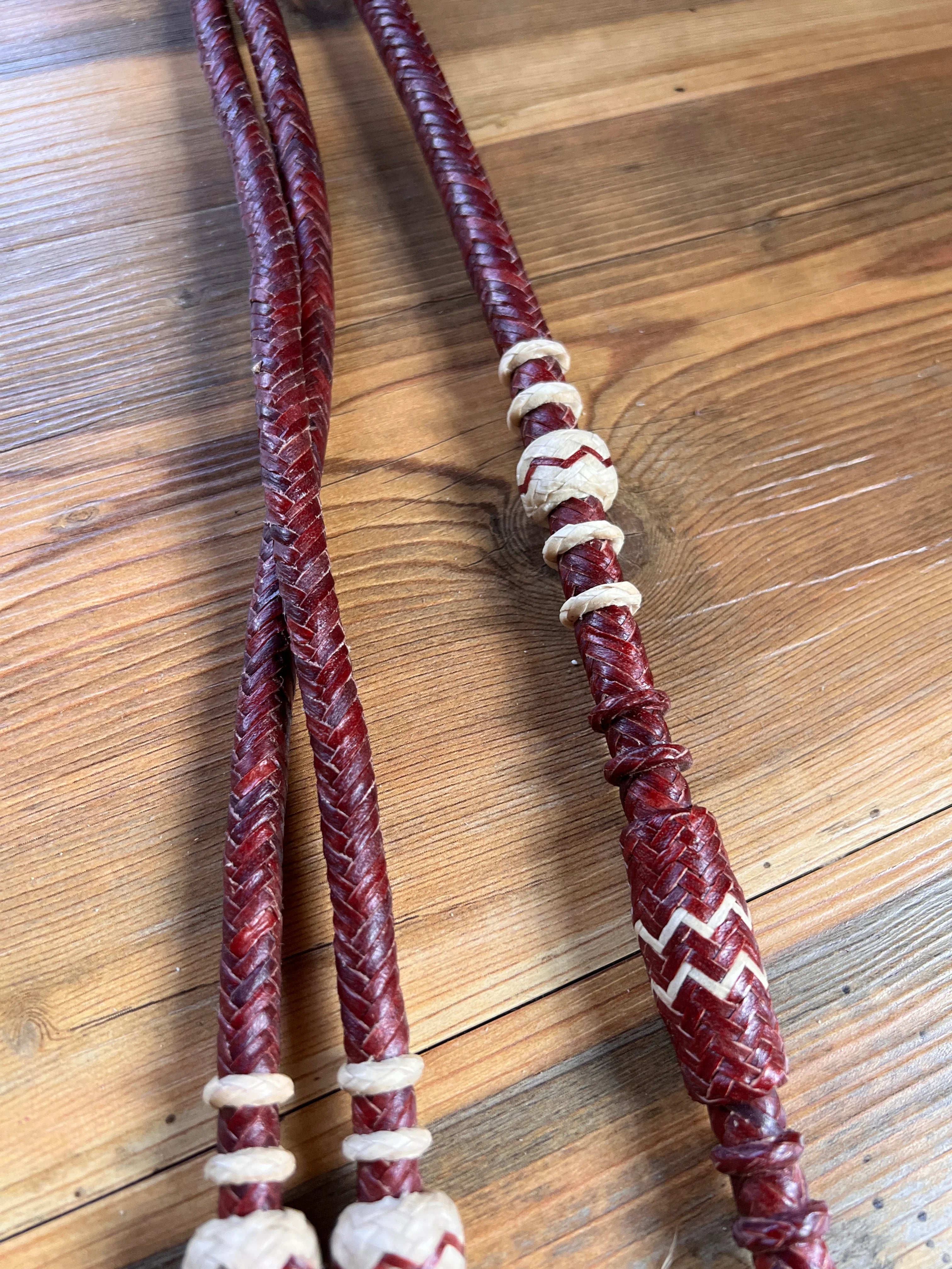 Red braided leather romal reins with cream accents and zigzag beads