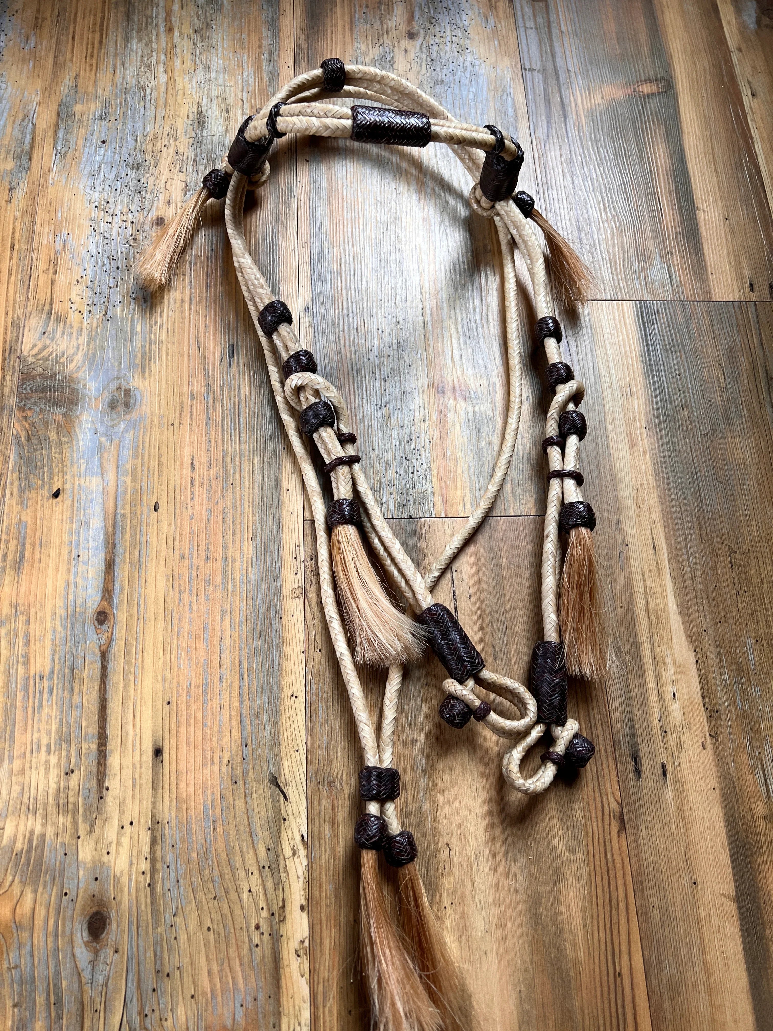 Hand-crafted beige black braided rope horse halter with leather accents, rawhide, mane tassels