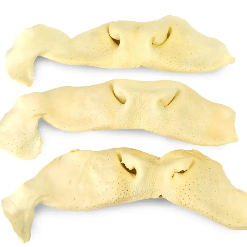 Three pale yellow face-shaped Beef Snouts pastries