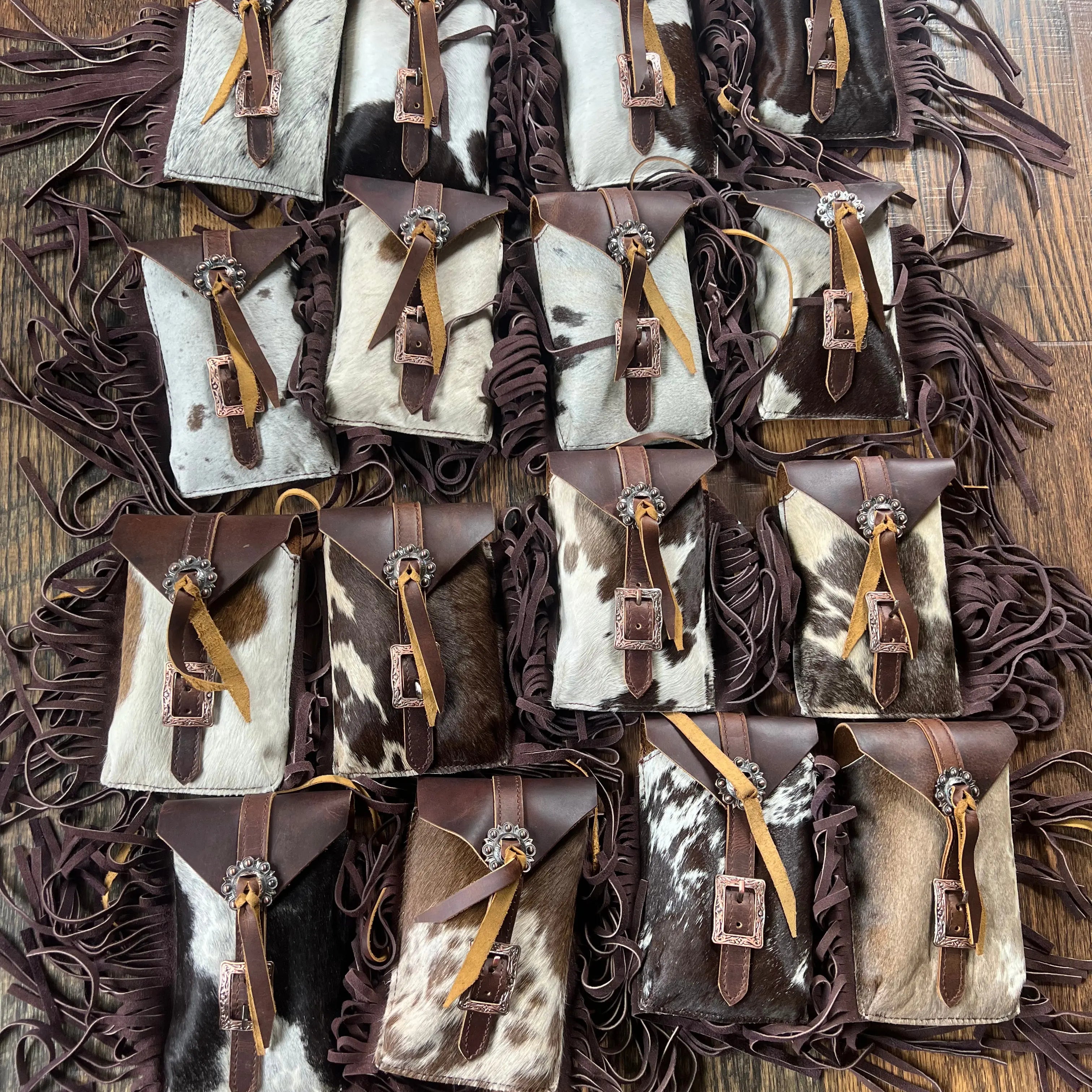 Brown and white hair-on cowhide saddle bag rear cinch with fringed pouches and brass buckles