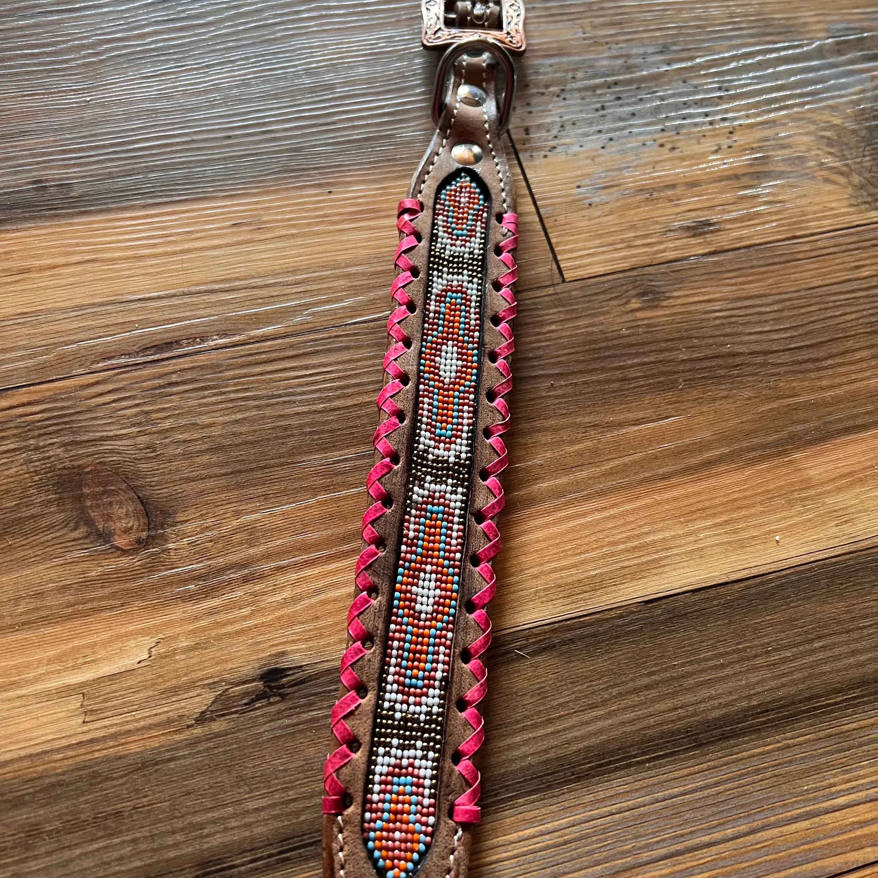 Genuine leather dog collar with pink, white, and gold southwest beaded inlay design, a rawhide wrapped edge Dog