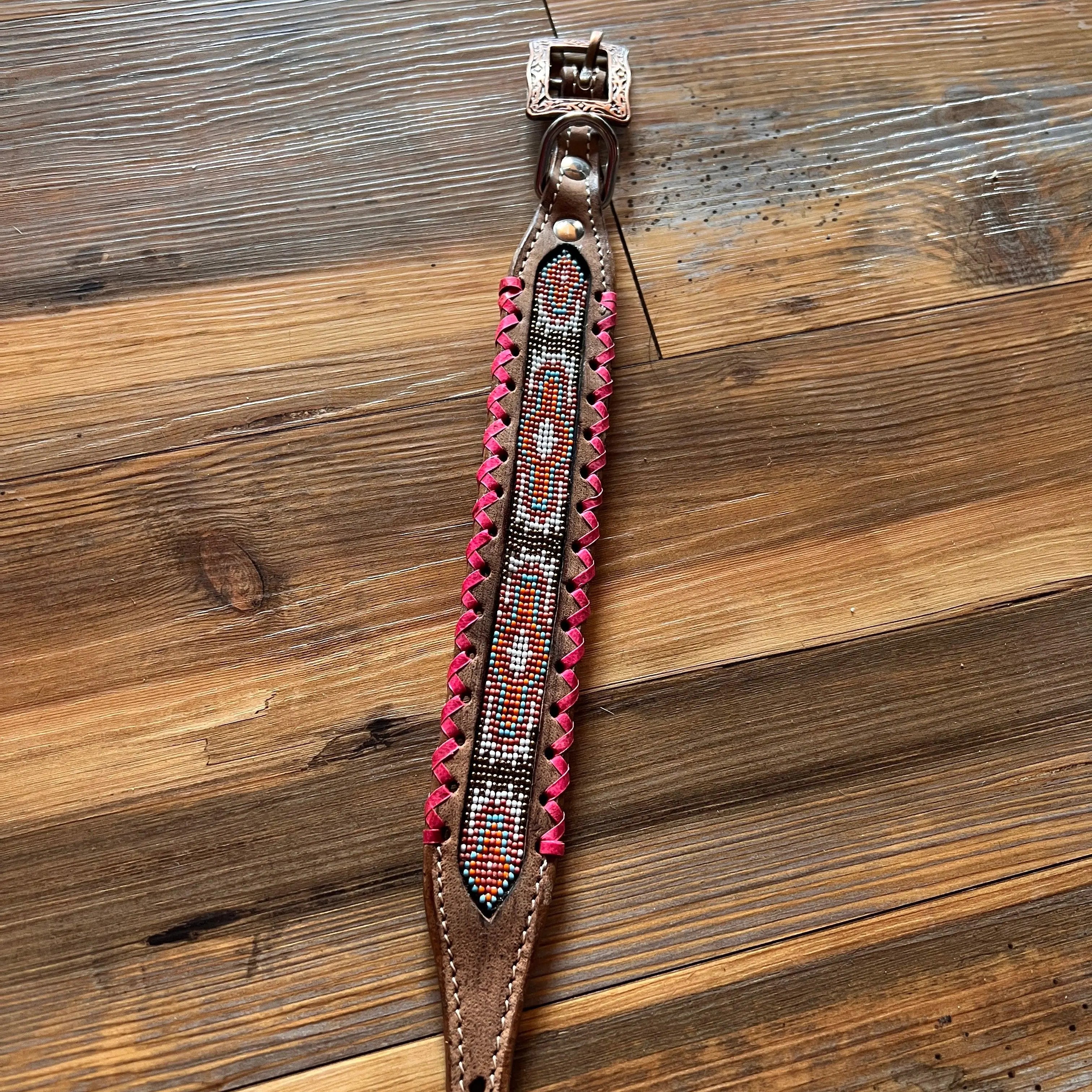 Genuine leather dog collar with pink, white, and gold southwest beaded inlay design, a rawhide wrapped edge Dog