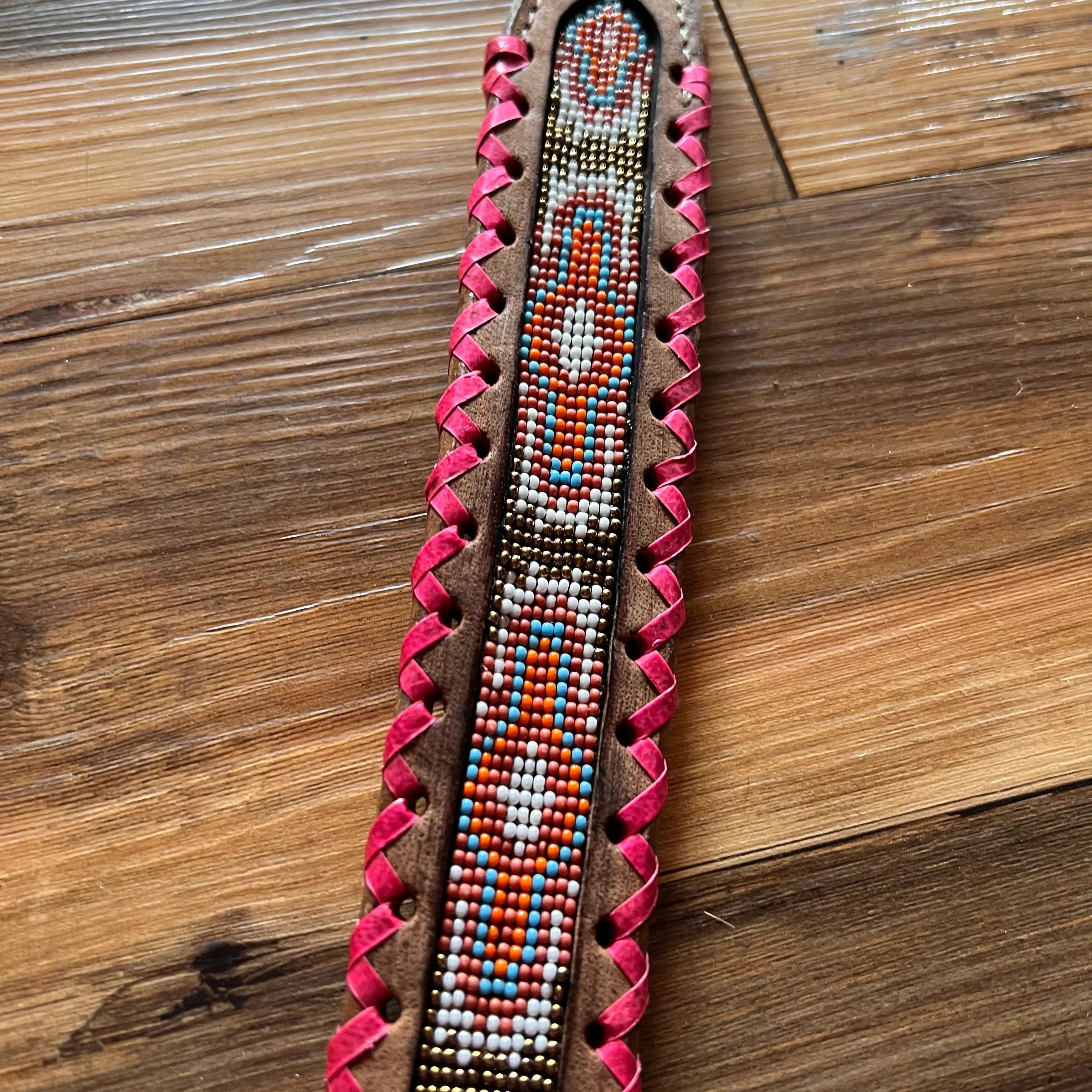 Genuine leather dog collar with pink, white, and gold southwest beaded inlay design, a rawhide wrapped edge Dog