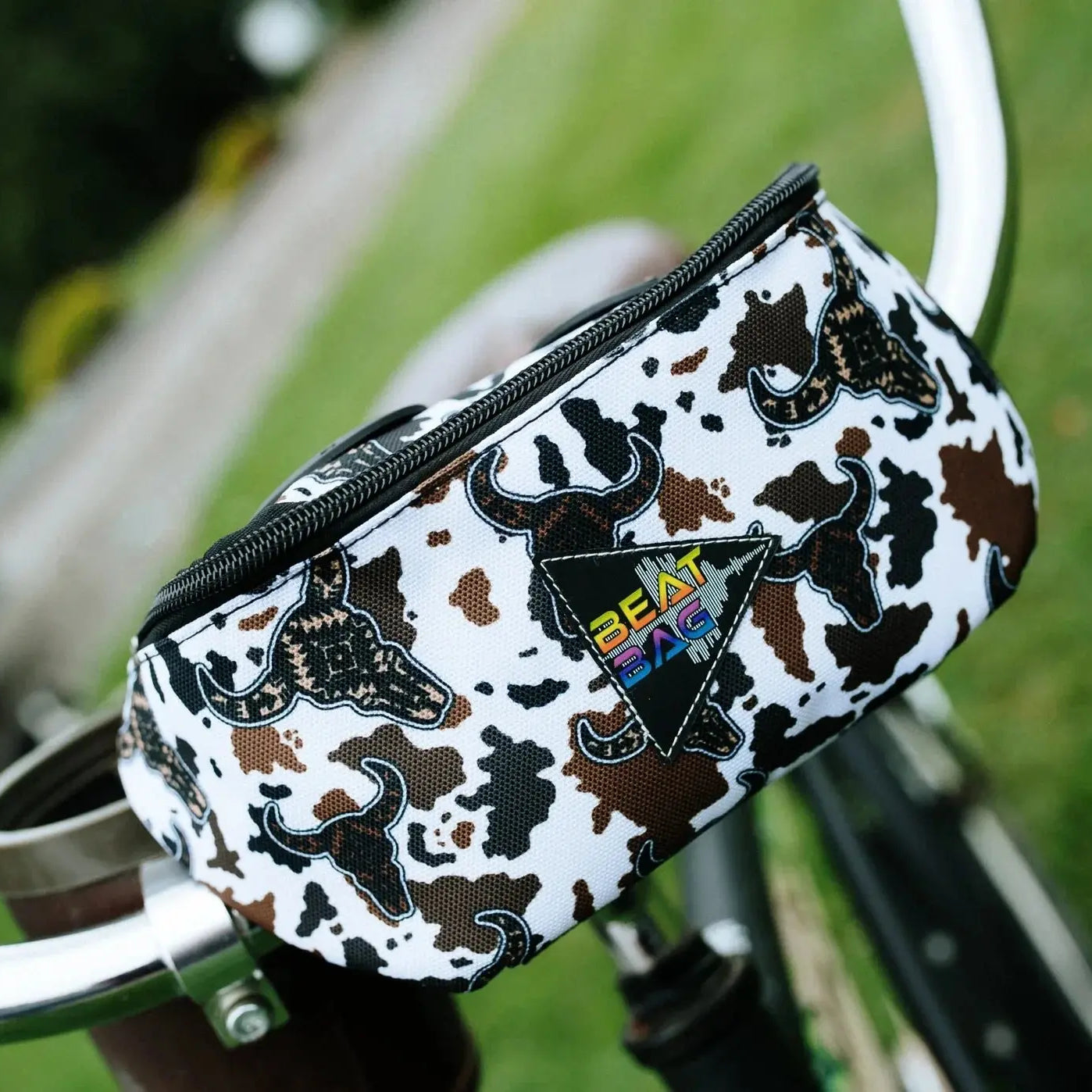 Beat Bag: white, black, brown cow-print bicycle bag with triangular logo patch