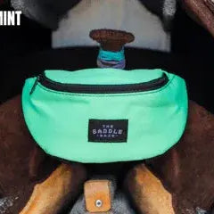 Neon mint Saddle Sack fanny pack with black zipper and branded patch