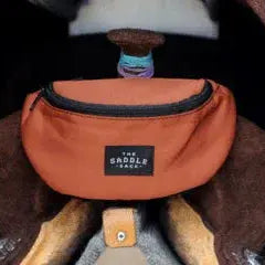The Saddle Sack orange saddle bag with black zipper and label