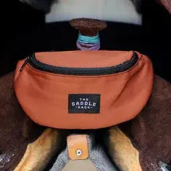 Orange The Saddle Sack fanny pack with black zipper and label