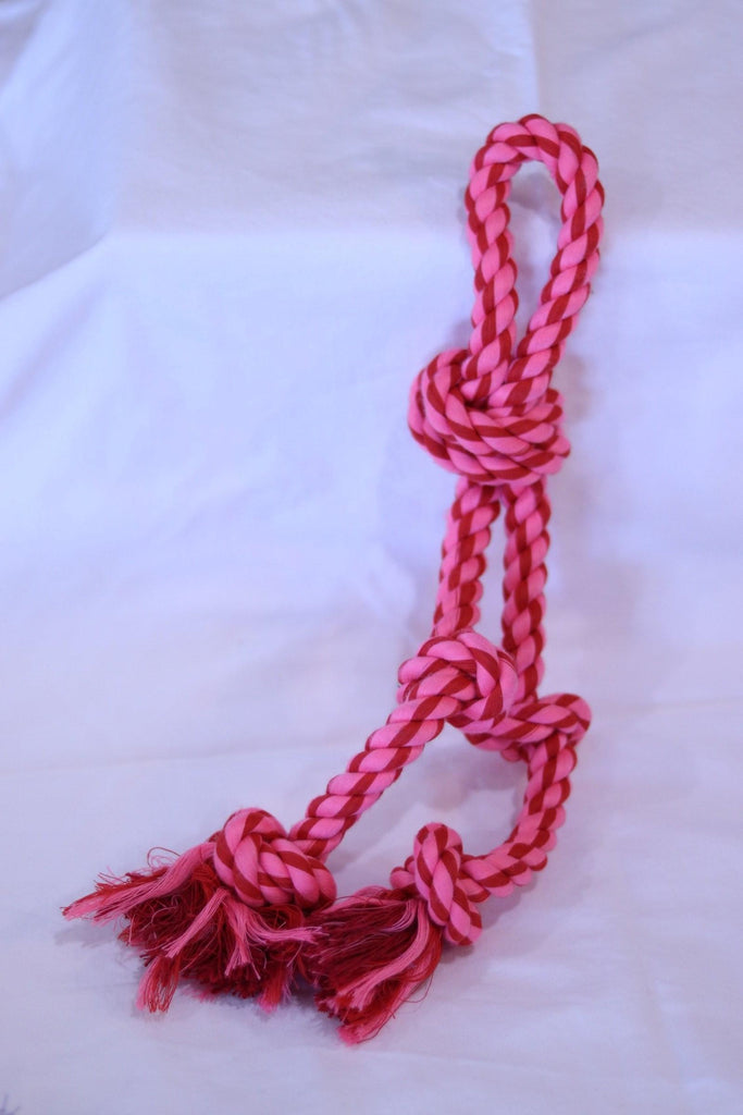 a pair of red scissors on a pink surface 