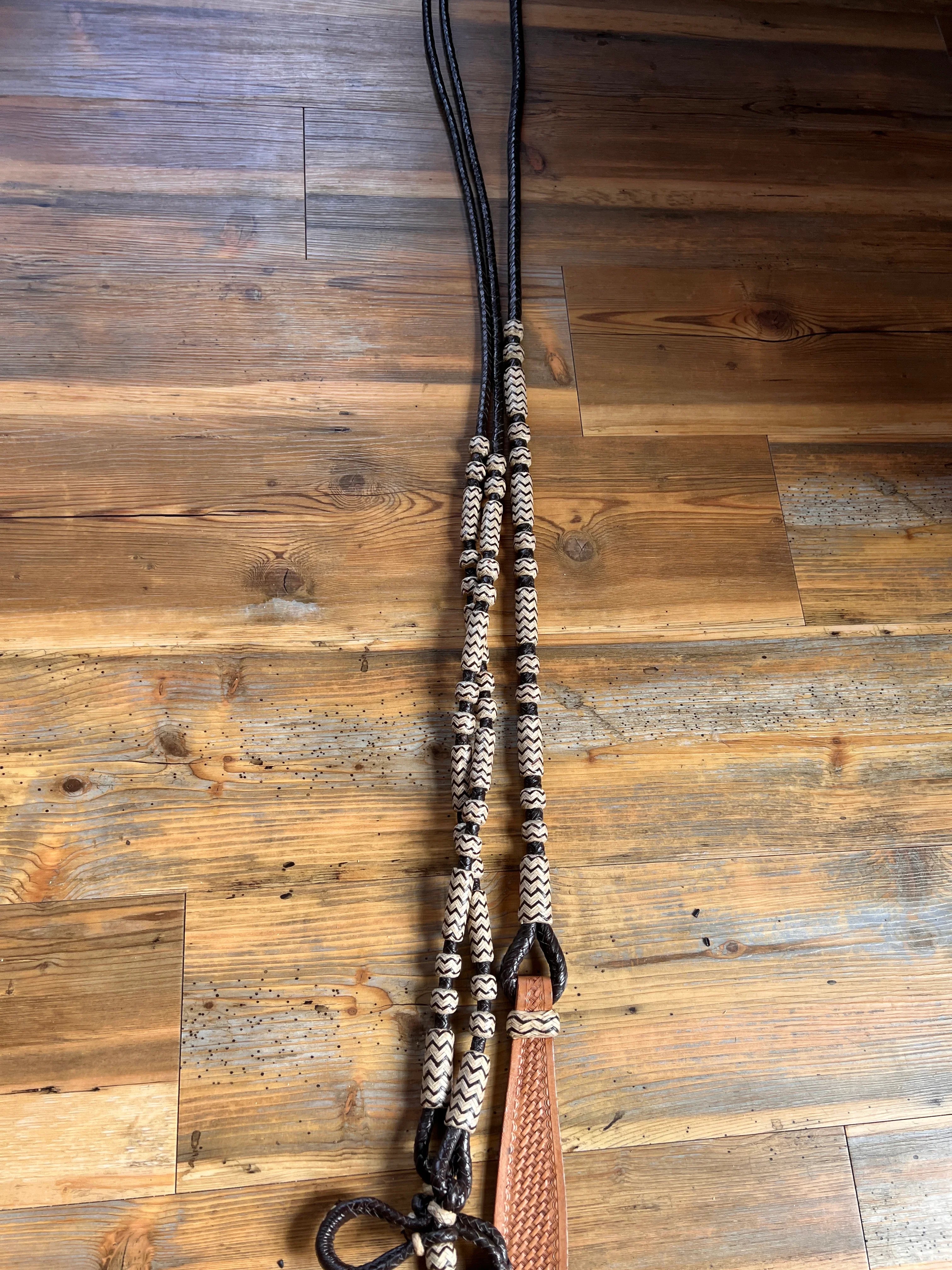 Black and cream 10-plait romal reins with tan strap, 55 inches