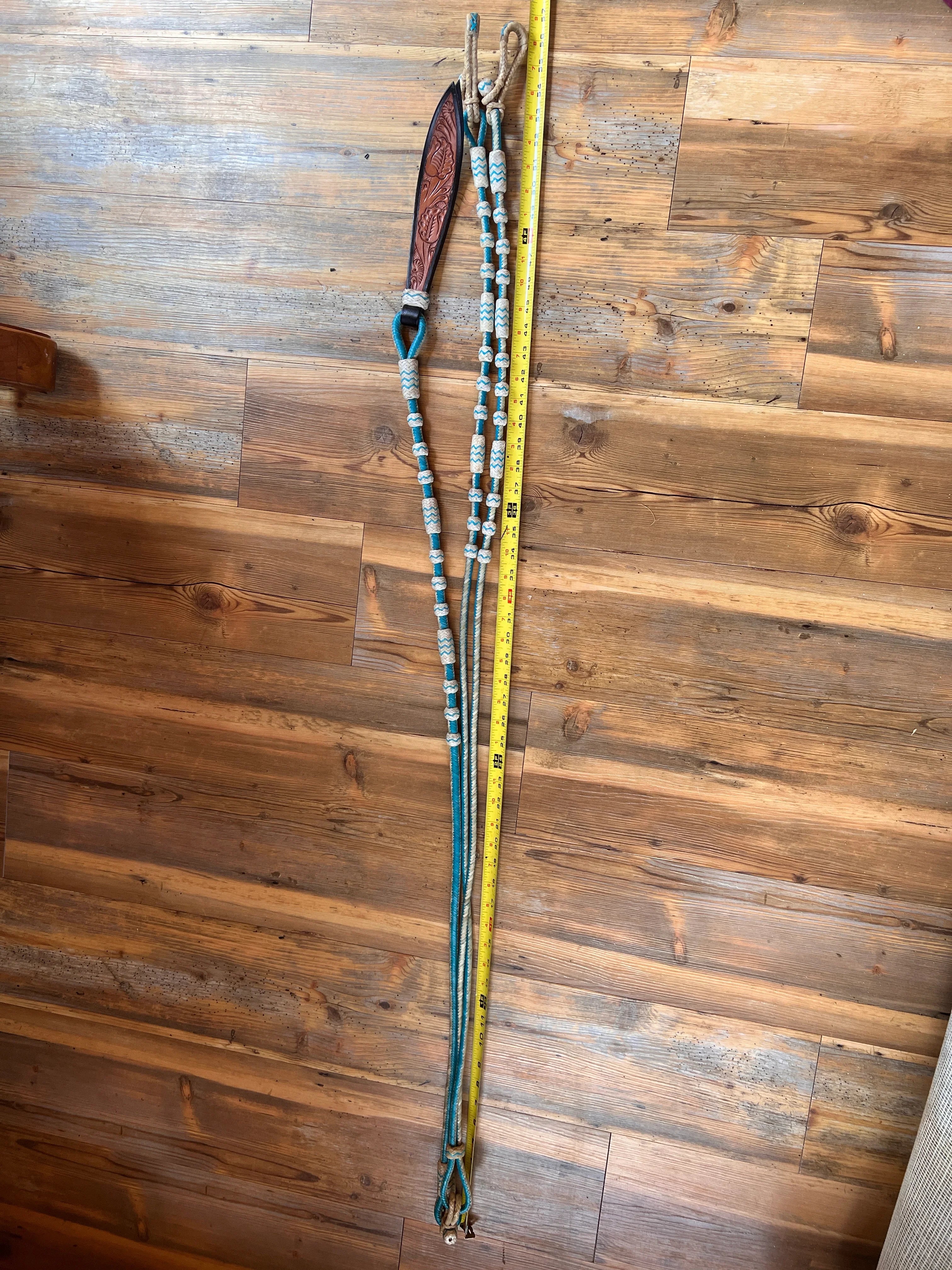 Teal and white 20-plait rawhide romal reins with brown leather handle