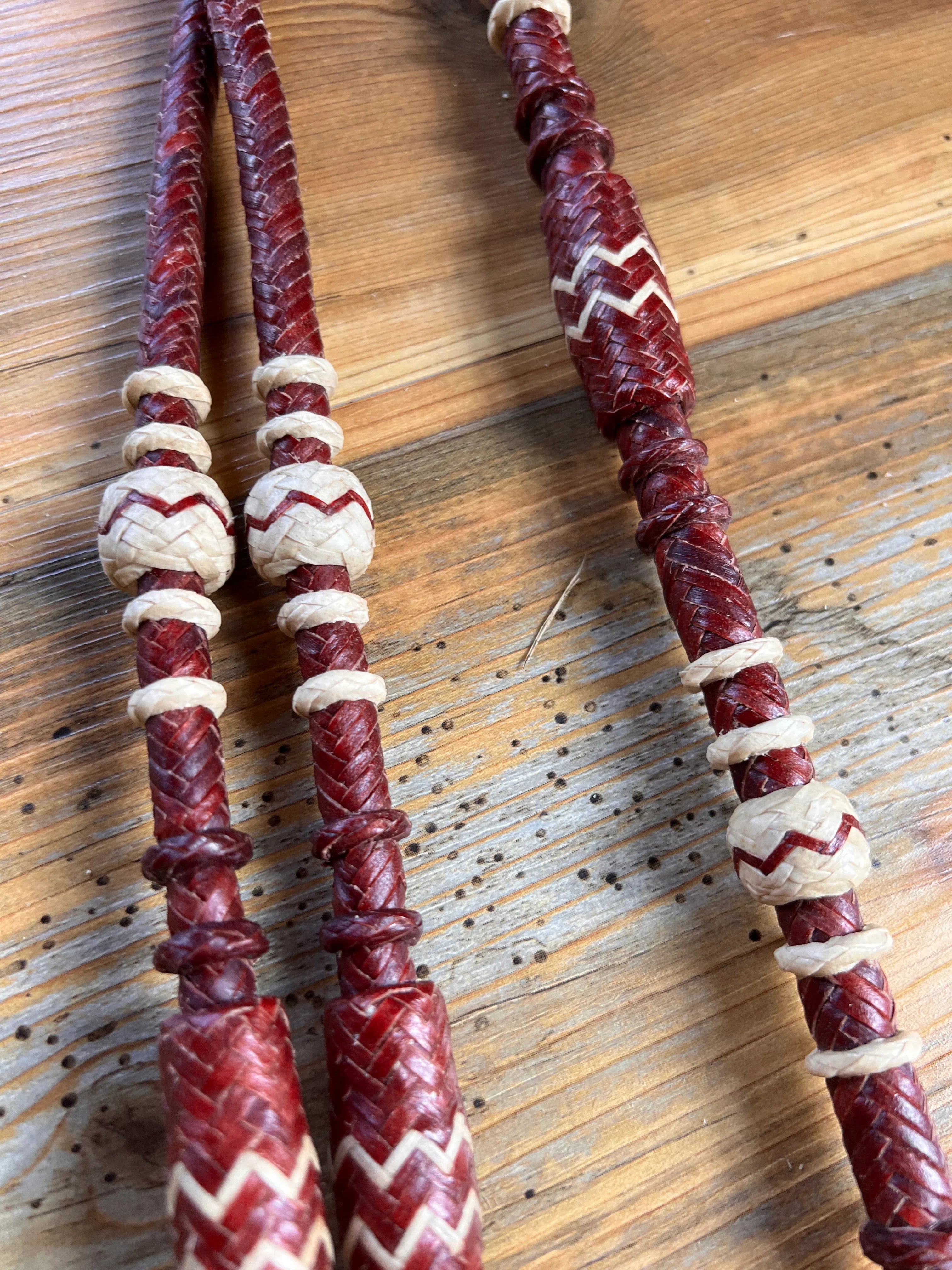 Red and cream braided leather romal reins with zigzag beaded handles