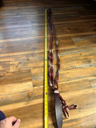 Maroon and cream braided leather halter strap with dark brown buckle on romal reins