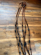 Brown leather Romal reins with black rawhide beaded accents