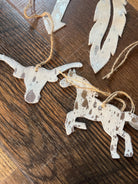 White and brown spotted silver acid wash cowhide animal ornaments on twine