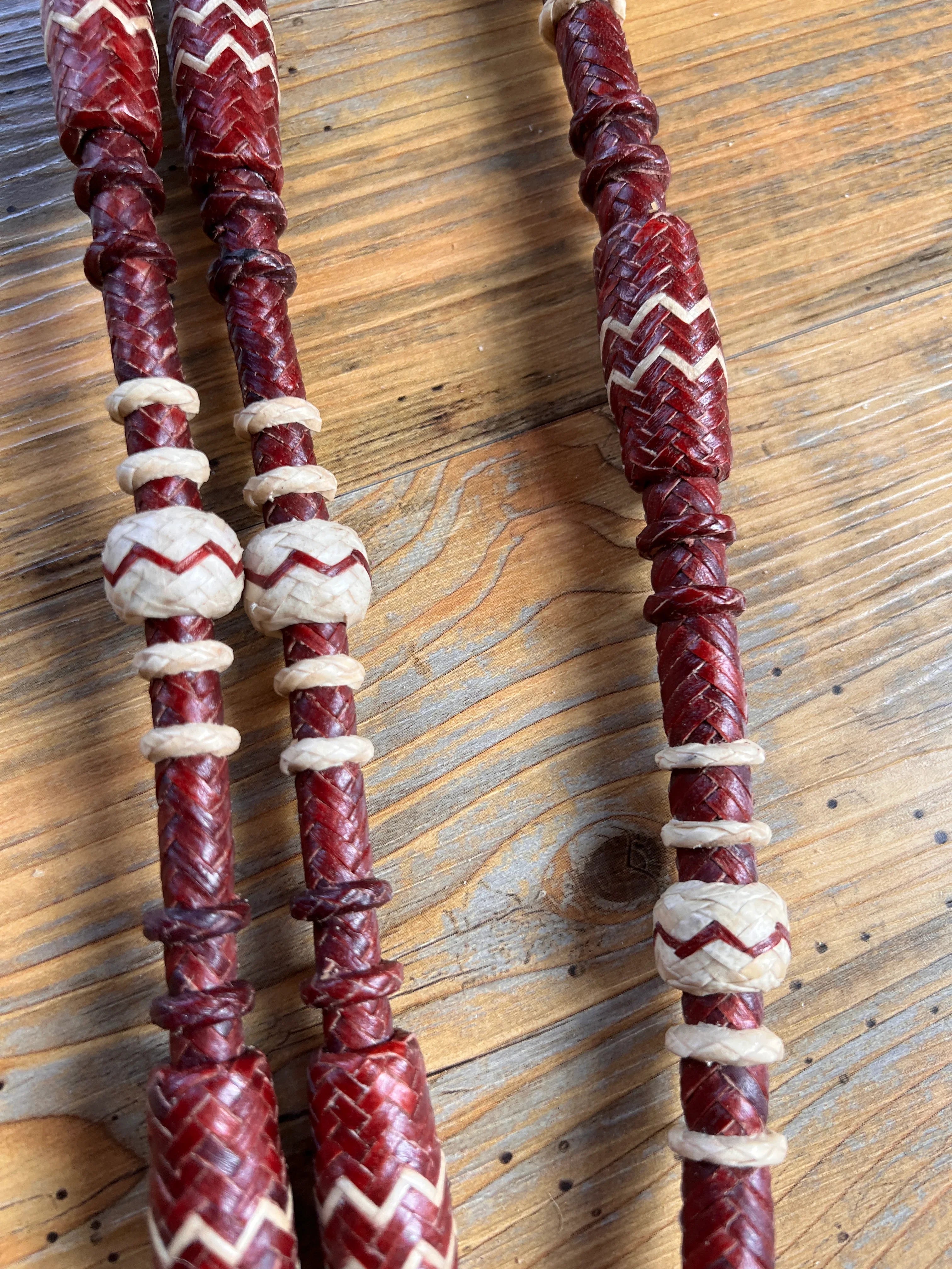 Red and cream braided leather romal reins with zigzag beaded handles