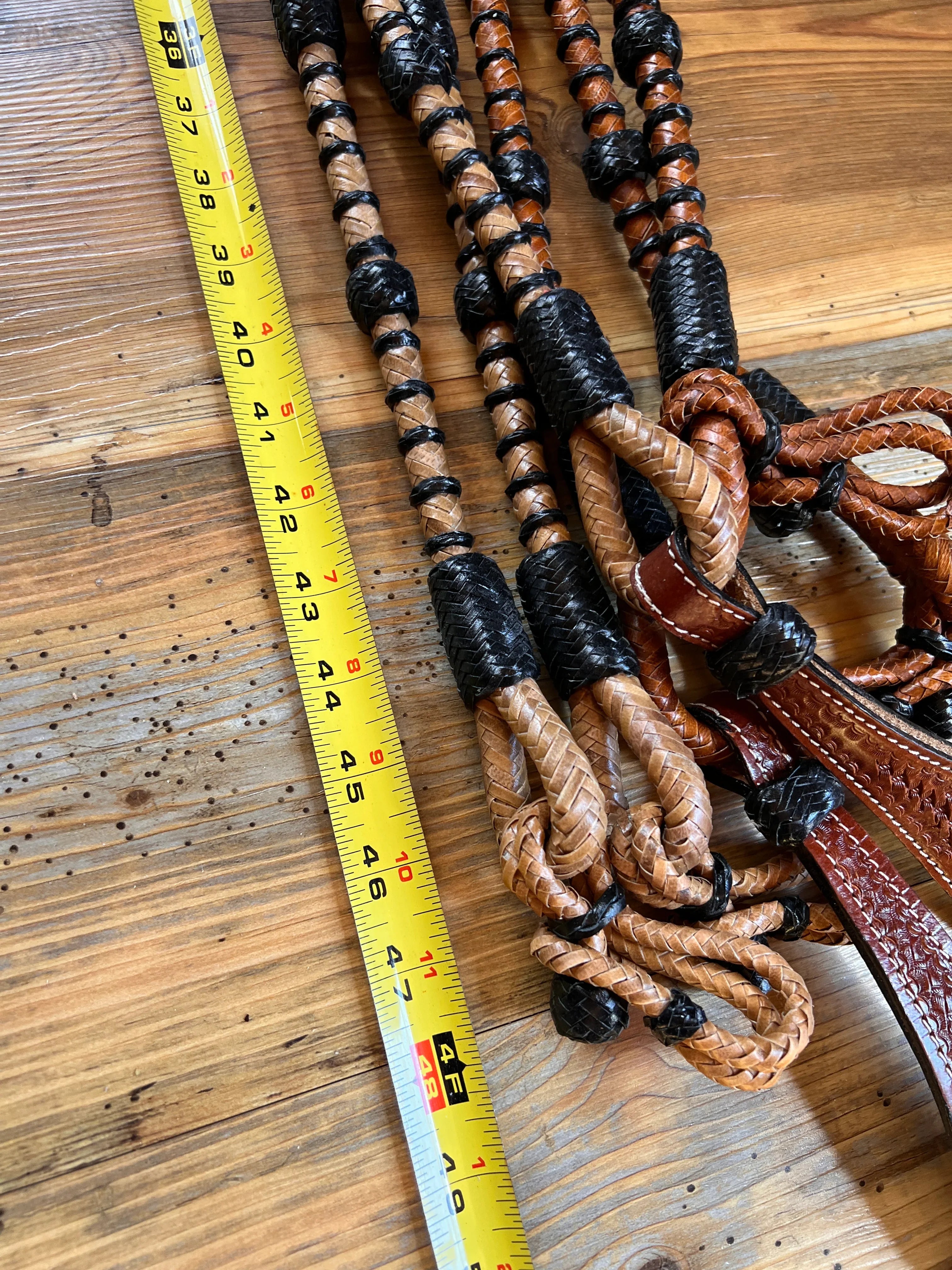Brown and black braided Romal reins with rawhide, woven texture