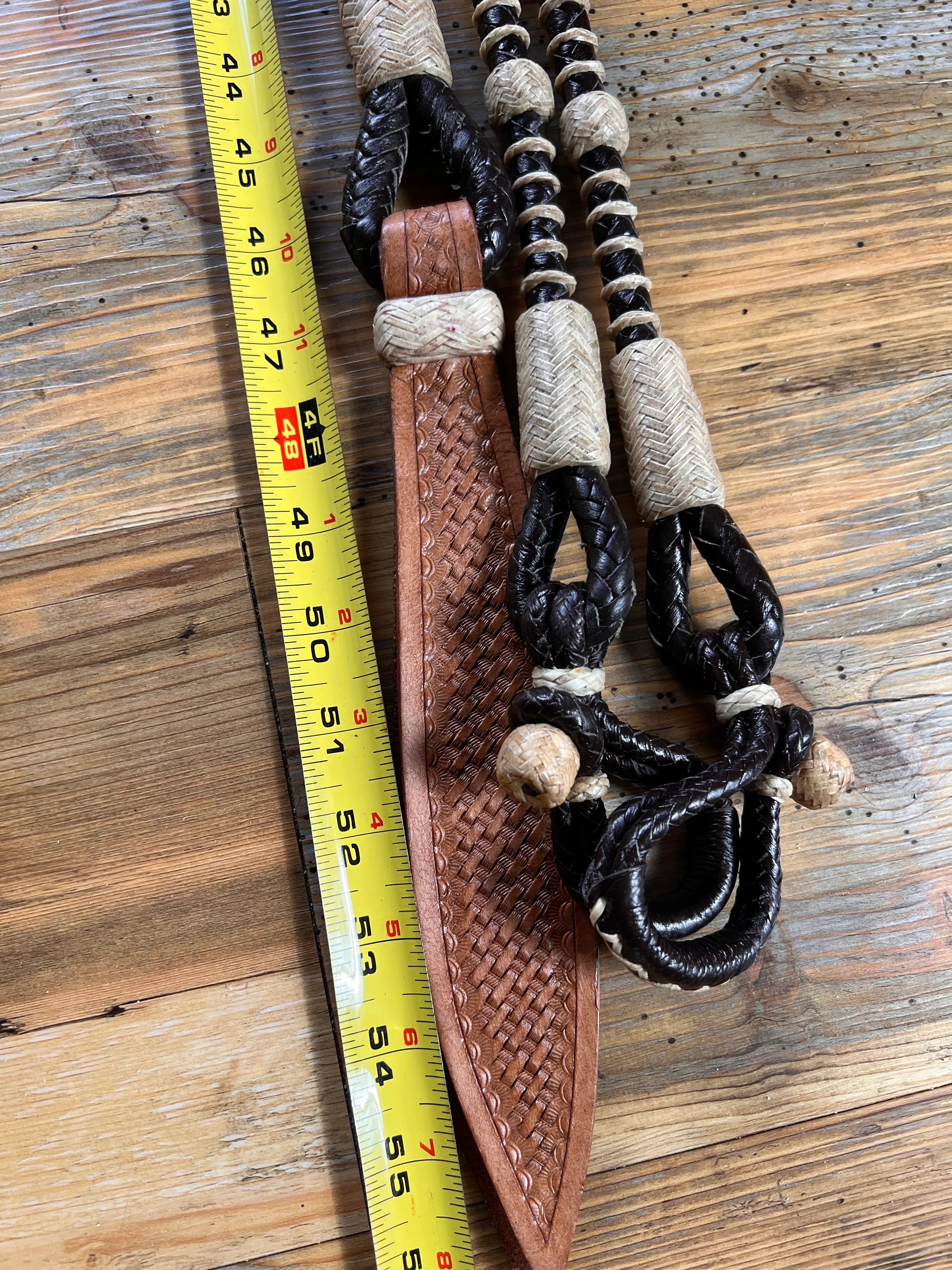 Brown woven leather halter on 55in 10-plait California romal reins with black rope and beige beads