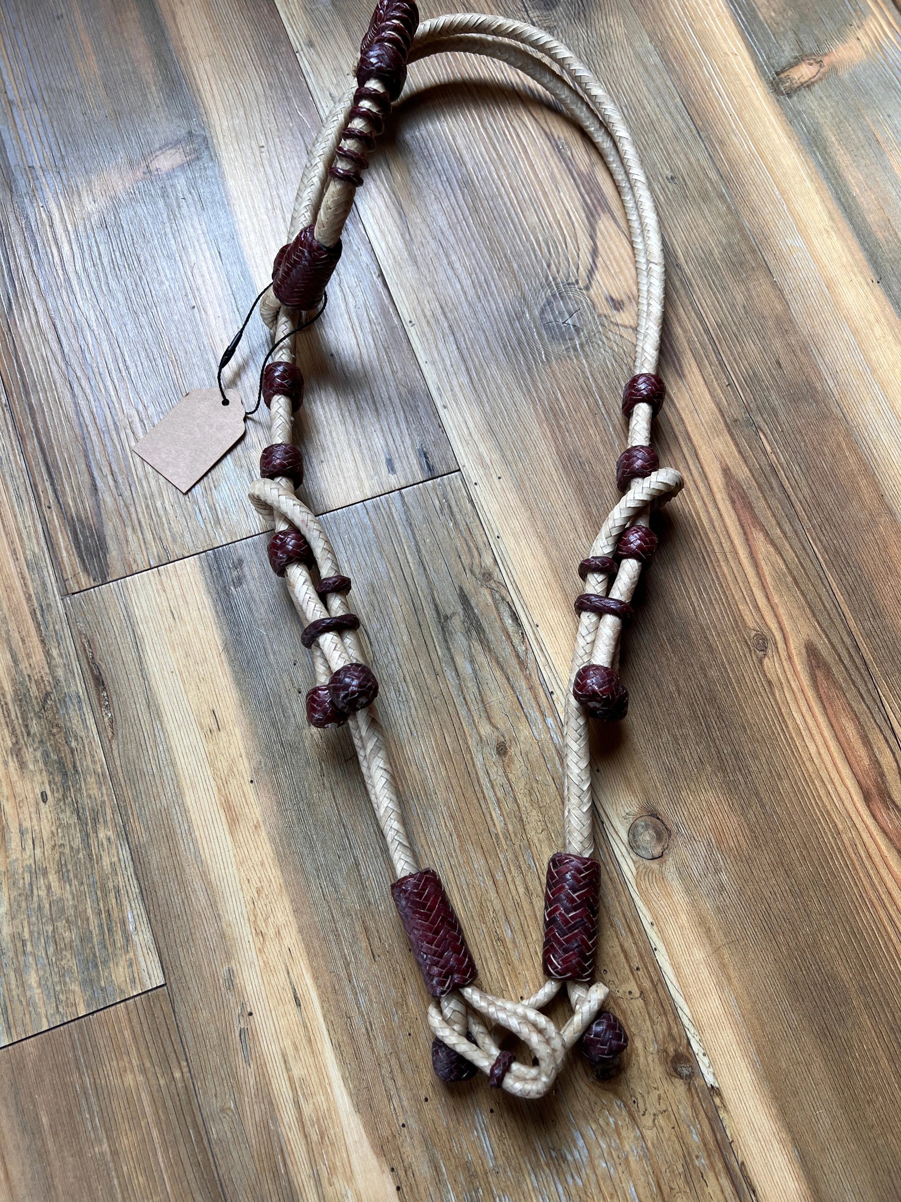 Hand-crafted natural rawhide braided one-ear Western horse headstall with cream and burgundy leather accents