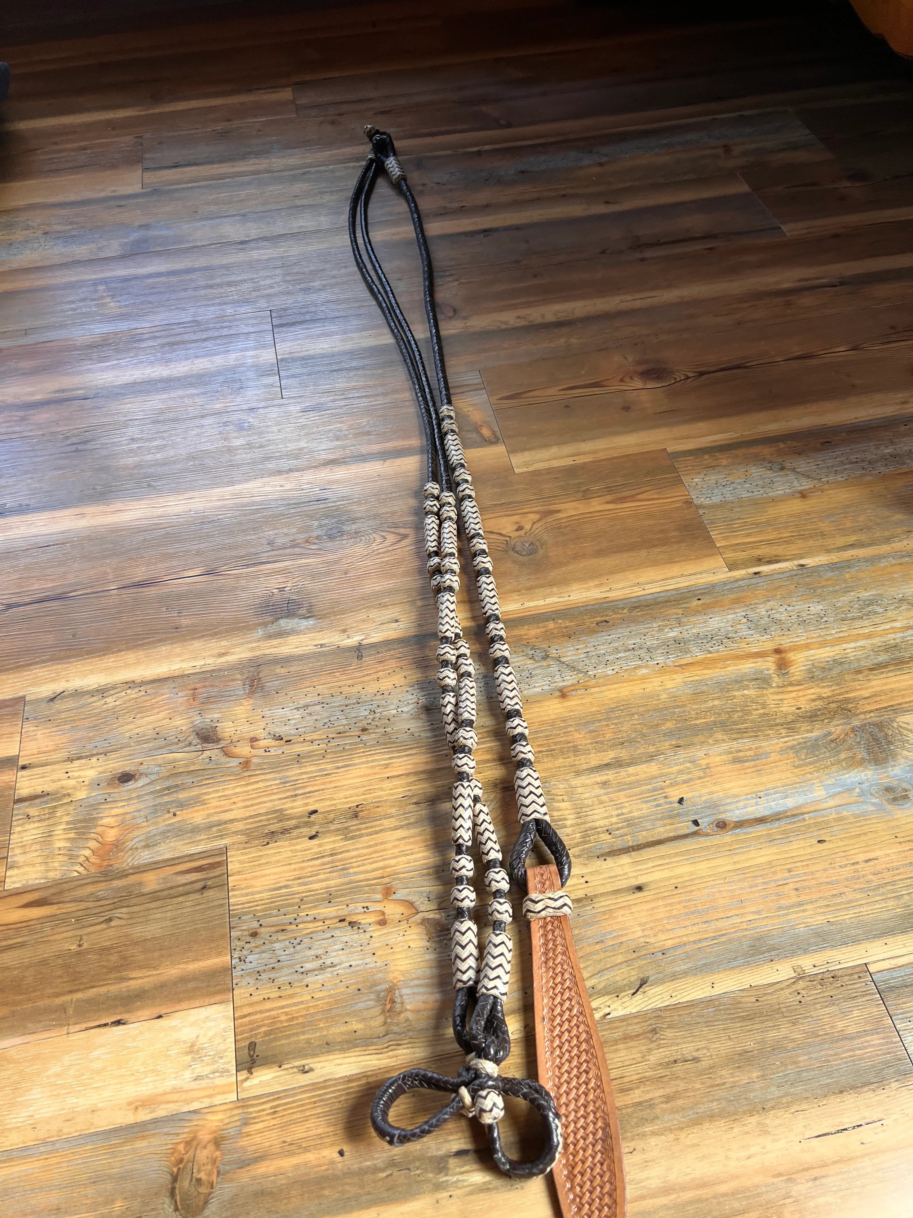 Brown leather horse halter with black rope and white zigzag beads, Romal reins