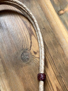 Braided light beige leather lanyard with dark red woven bead on natural rawhide headstall