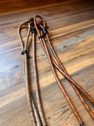 Brown braided leather lanyards with black plastic clasps on Romal Reins with Black Rawhide
