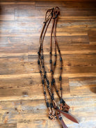 Romal reins with black rawhide in brown leather, beaded accents, braiding