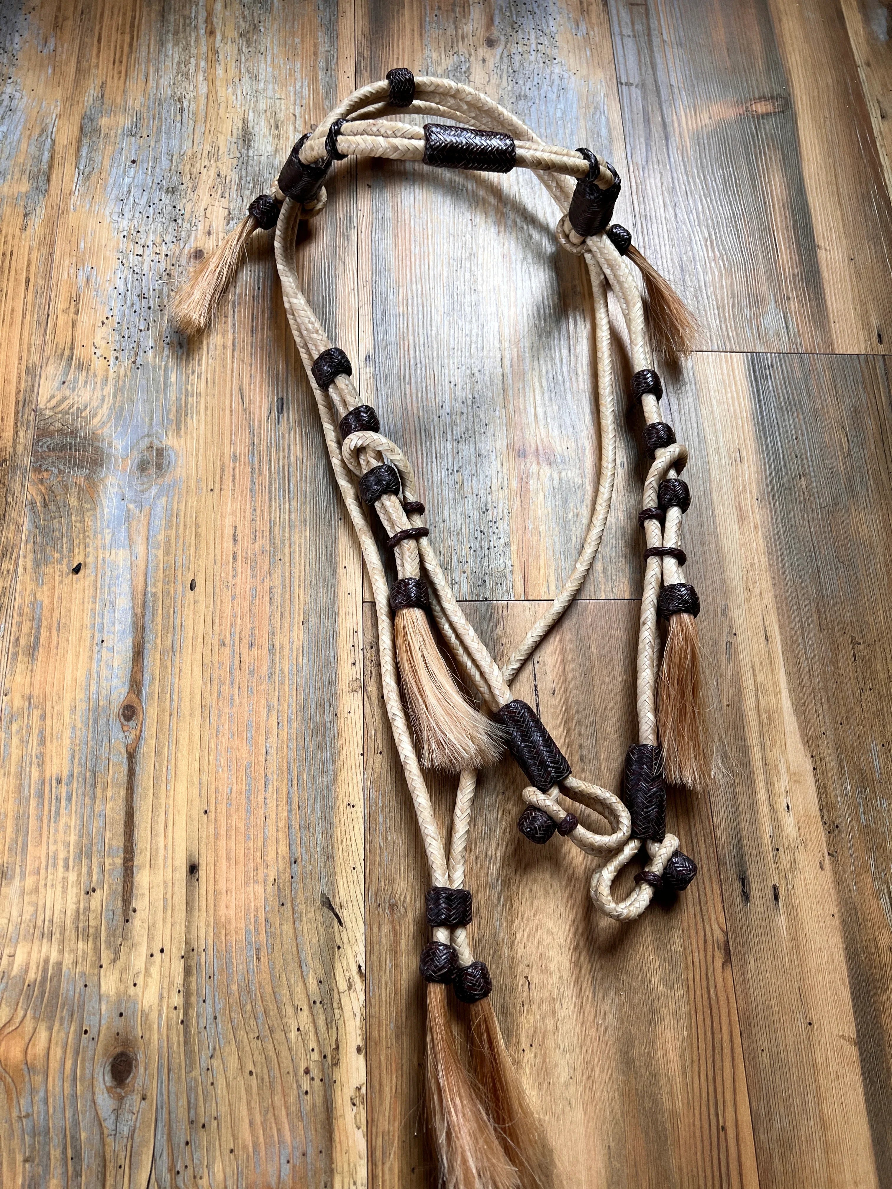 Hand-crafted beige black 16-plait rawhide horse headstall with mane tassels