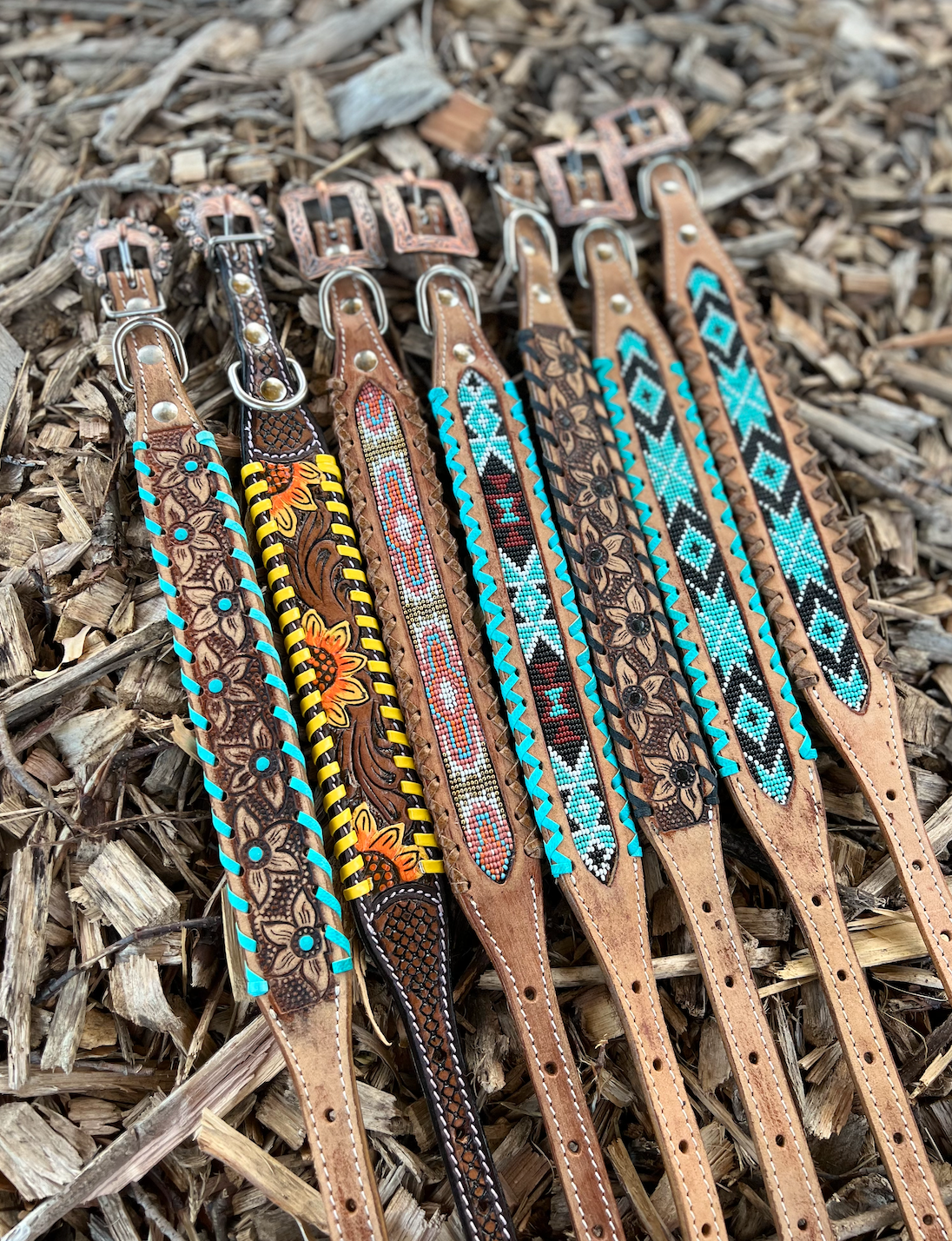 Handcrafted leather dog collars featuring intricate beaded and tooled designs in earthy tones with vibrant turquoise accents.