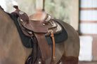 Brown leather western saddle with silver conchos on Benefab black pad