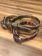 Three dog collars with metallic buckles in leopard, sunflower, striped patterns